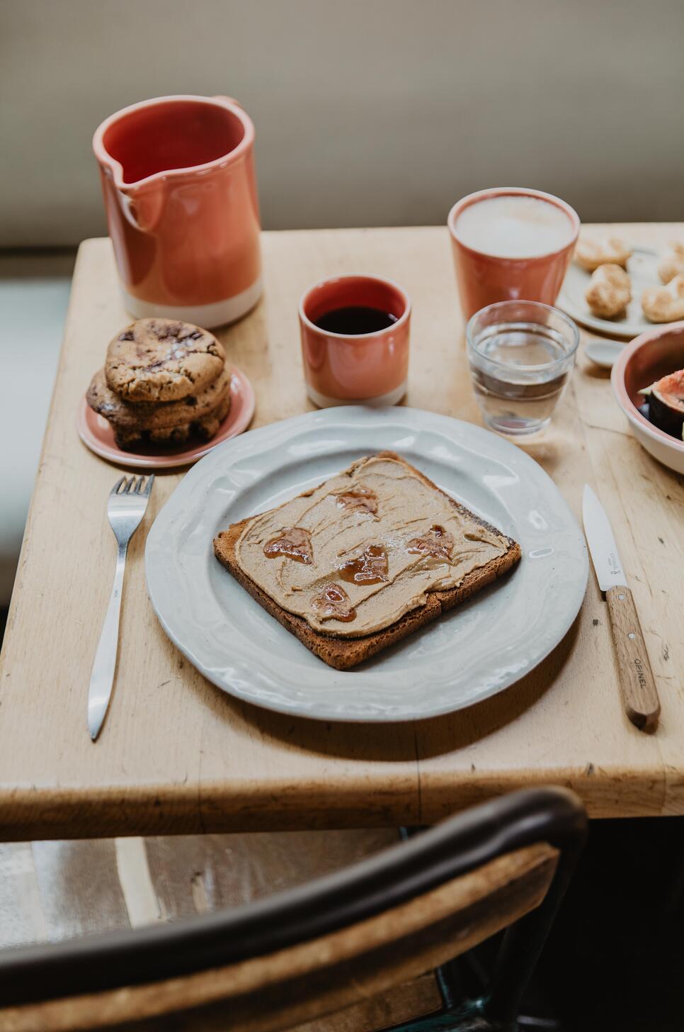 Table de café avec toast de cacahuètes et thé dans gobelet en céramique Jars